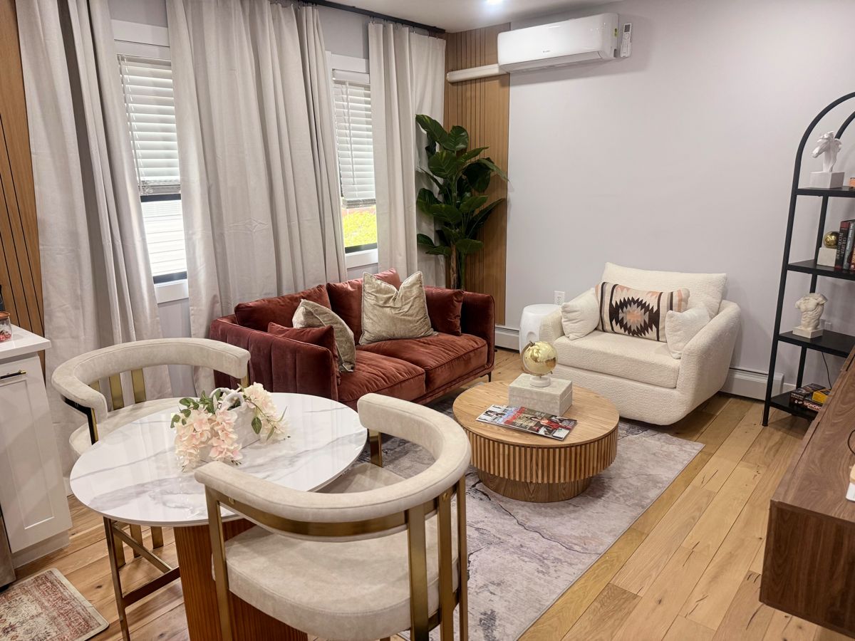 Velvet Vue Suite living room with a rust velvet sofa, boucle armchair and marble dining table